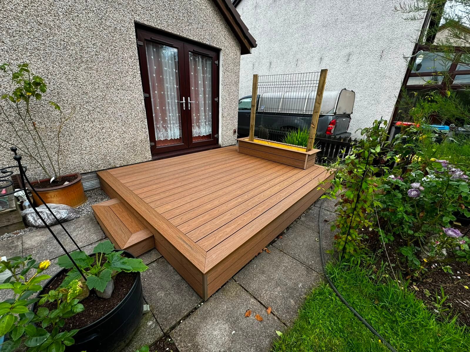 Brown composite decking with a built-in planter and steps